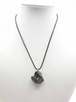 Una collana CIONDOLO DI SHUNGITE ELITE con sopra una pietra nera.