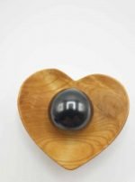 A black pearl in a wooden bowl in the shape of a SHUNGITE SPHERE 4 CM.