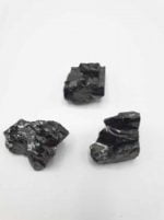 Tre pezzi di PIETRA PEPITE SHUNGITE ELITE GREZZA su fondo bianco.