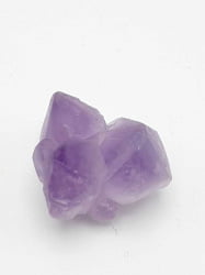 A RAW AMETHYST on a white surface.