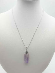 An amethyst pendant on a mannequin.