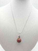 A MOOKAITE PENDANT with a red stone.