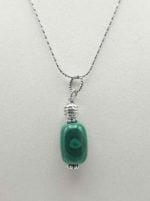 Un CIONDOLO PENDENTE DI MALACHITE su una catena d'argento.