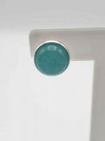 One clip-on earrings with jade on a white coffee table.