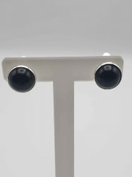 Coppia di orecchini Orecchini a clip con onice nera su supporto bianco.