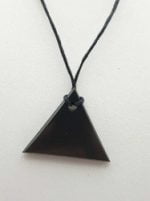 Un ciondolo di shungite triangolo maschile nero su un cordino nero.
