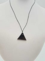 Un ciondolo di shungite triangolare maschile su un manichino.