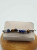 Un BRACCIALE UOMO CON SODALITE, OCCHIO DI TIGRE E CORDINO CUOIO MARRONE CHIARO blu e argento con scatola.