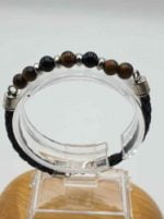 Un bracciale con perline occhio di tigre e pelle nera; BRACCIALE DA UOMO CON ONICE NERO, OCCHIO DI TIGRE E CORDINO CUOIO MARRONE INTRECCIATO.