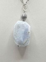 A blue CHALCEDONY PENDANT PENDANT on a silver chain.