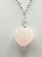 Il CIONDOLO PENDENTE IN QUARZO ROSA A CUORE è su una catena di argento.