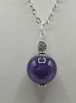A pendant with purple amethyst on a silver chain.