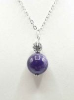 A SPHERE AMETHYST PENDANT PENDANT on a silver chain.