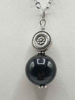 A PENDANT PENDANT BLACK TOURMALINE BALL NECKLACE with charm pendant on silver chain.