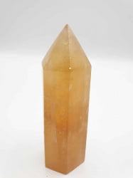 A PUNTA OBELISCO CALCITE GIALLA DORATA su sfondo bianco.