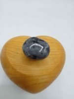 Una pietra del cuore BURATTATA LARVIKITE appollaiata su una scatola di legno BURATTATA.
