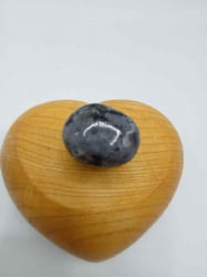 Una pietra del cuore BURATTATA LARVIKITE appollaiata su una scatola di legno BURATTATA.