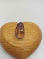 Una pietra AMETRINO BURATTATO in una scatola di legno a forma di cuore.