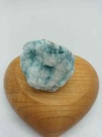Un pezzo di ARAGONITE BLU GREZZA appoggiato sopra un cuore di legno.
