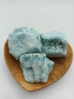 Tre pezzi di ARAGONITE BLU GREZZA su piatto di legno a forma di cuore.