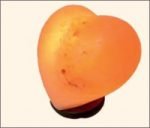 An orange HEART SALT LAMP on a stand.