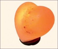 An orange HEART SALT LAMP on a stand.