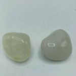 Two pieces of white jade on a white background, Tumbled Sulphurous Quartz.