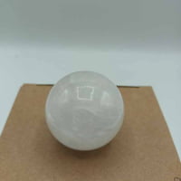 A white ball perched on top of a cardboard box, which encloses the 4 CM ROCK CRYSTAL BALL.