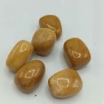 Un gruppo di pietre GIADA GIALLA BURATTATA su una superficie BURATTATA.