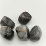A collection of TUMBLED TOURMALINATED QUARTZ stones on a white surface.