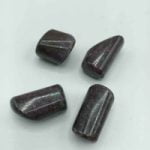 Set di quattro cabochon RUBINO CIANITE BURATTATO su superficie bianca.