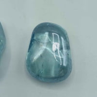 Due pietre Aqua Aura Azzurra Burattata Qualità A su una superficie chiara.