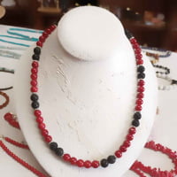 A COLLANA BAMBOO CORAL E PIETRA LAVICA NERA con perline di corallo rosso e nero su manichino.