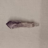 An AMETHYST SCETTRO point on a white surface.