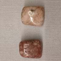 Pair of pink and white PINK ZEBRA JASPER stones on a white background.