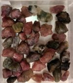 Cristalli di tormalina rosa in un contenitore di vetro trasparente decorato con cristalli TORMALINA POLICROMA.