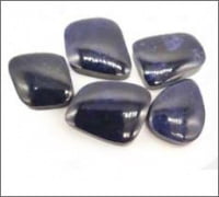Collection of ZAFFIRO BLU TUMET stones on a white background with tumbled finish.