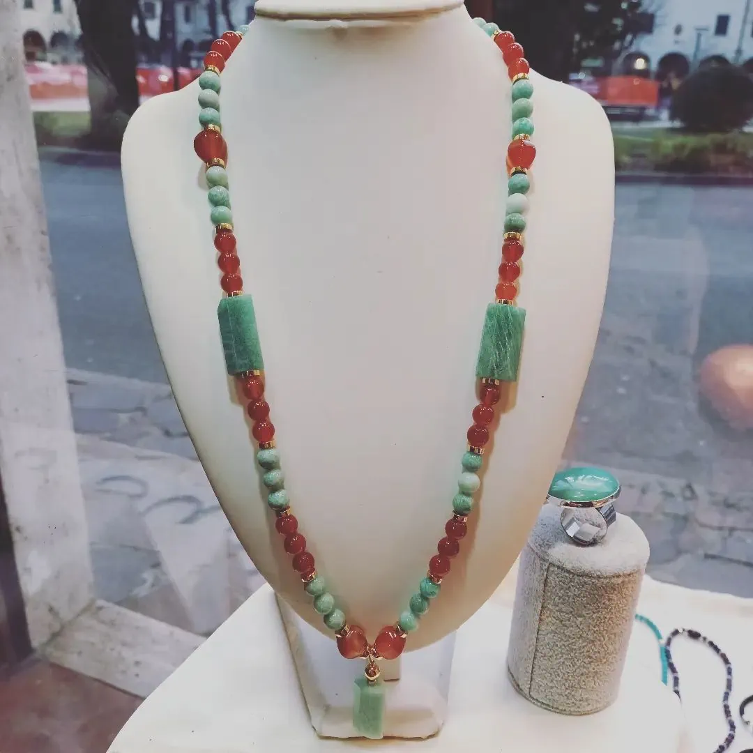 Un display per la casa con una collana con perline rosse e verdi.